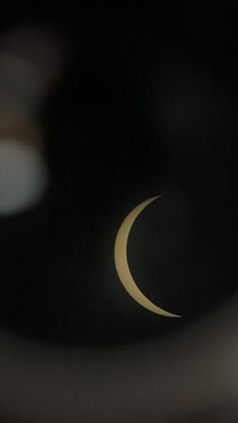 This striking photo captures a partial solar eclipse, revealing a golden crescent of the sun against a deep black sky